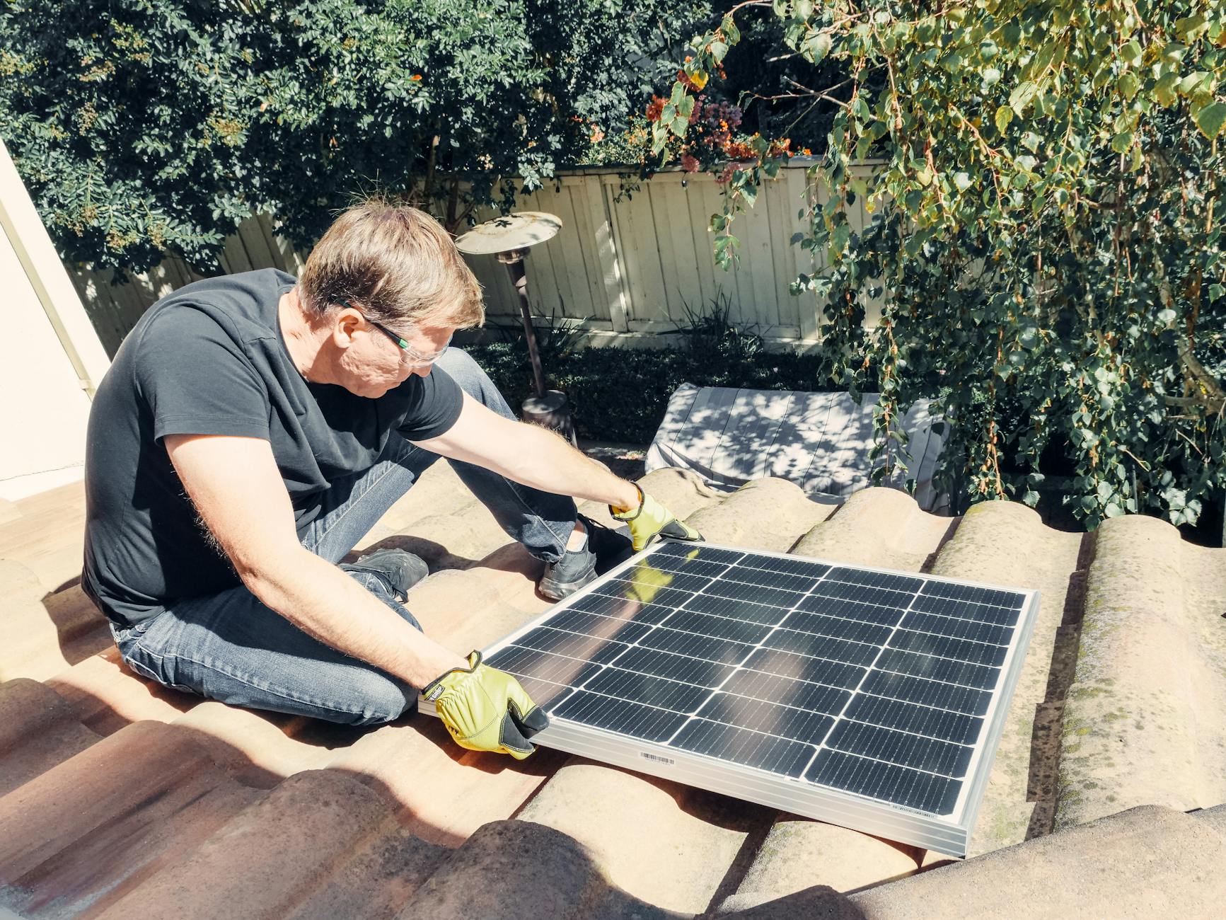 A professional roofing contractor from Storm Guard Roofing inspecting a concrete tile roof in a Las Vegas neighborhood, pointing out a potential issue to a homeowner.
